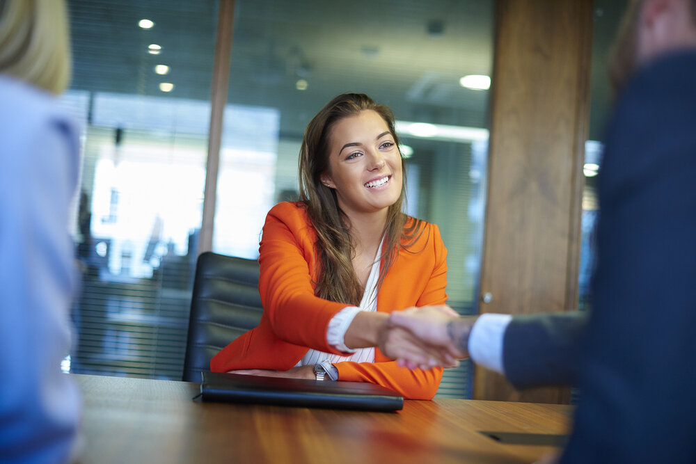 Female candidate for executive position shaking hands after an interview